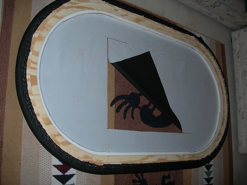Black padded vinyl poker table rail fitted onto the oval wood base during assembly
